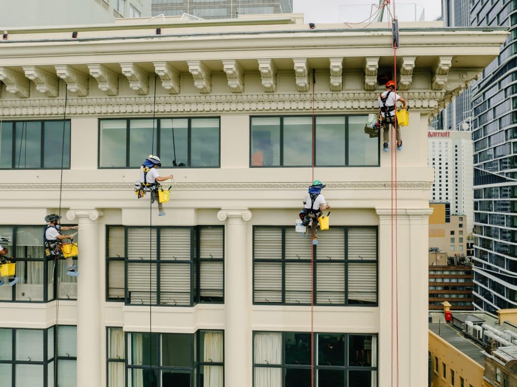 Five members of the Anchor Safe Rope Access team use aabseil to paint the facade of the Astor Apartments in Sydney