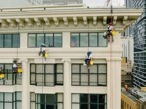 Five members of the Anchor Safe Rope Access team use aabseil to paint the facade of the Astor Apartments in Sydney