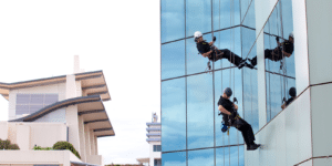 Two Anchor Safe Rope Access technicians abseil the glass facade of one of Sydney's high-rise office buildings building
